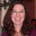 Headshot of Cathy White. Cathy has long, brown, wavy hair. She is smiling. 