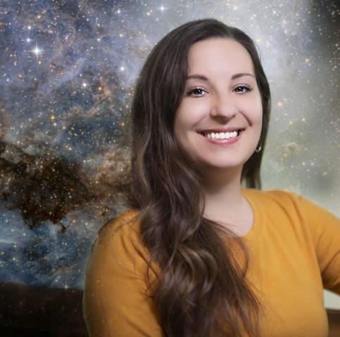 Headshot of Morgan. She has long brown hair. She is wearing a yellow top and is smiling. 